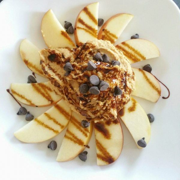 Peanut butter chocolate chip dessert hummus with apples overhead shot