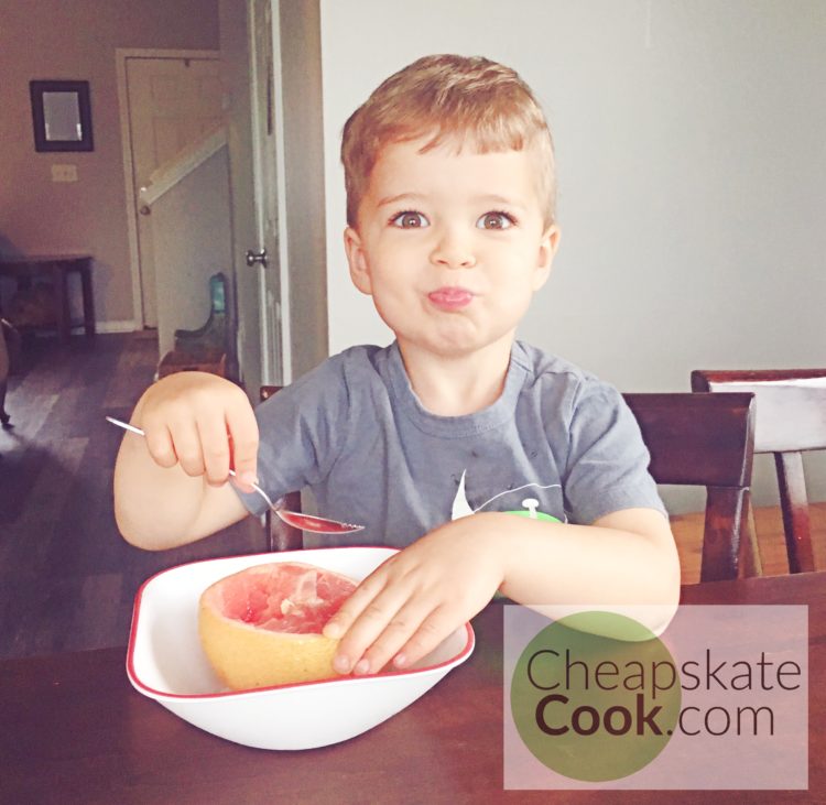 Kid eating grapefruit