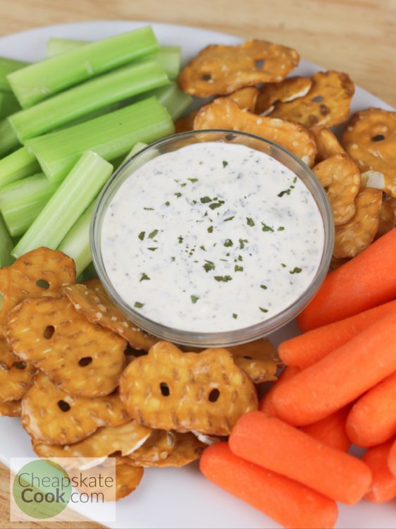 Ranch dip overhead shot in a bowl surrounded by celery, carrots, and pretzels