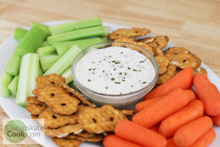 Ranch dip in a bowl with celery, carrots, and pretzels
